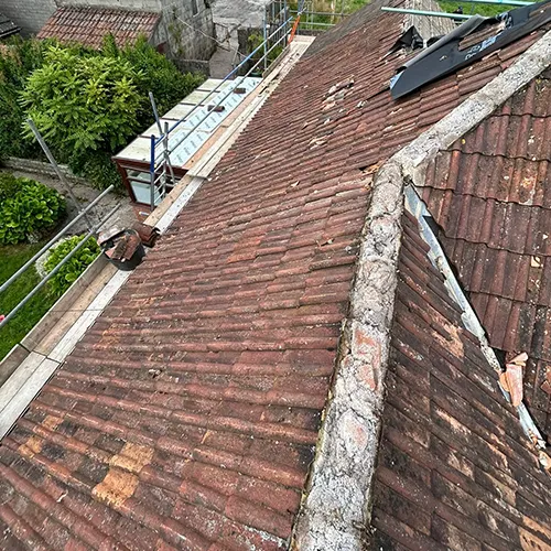 A view of the roof of a building with a satellite dish on top of it.