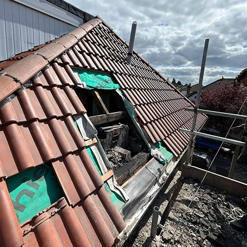 A man standing on top of a roof next to a building.